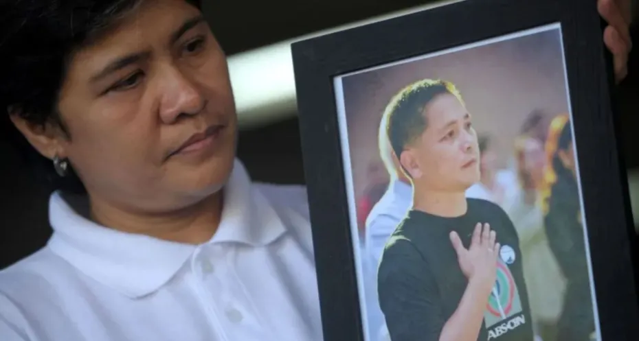 Gerry Ortega's wife, Patria, holds a photo of the Philippine journalist.