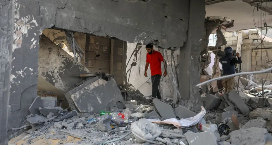 Palestinians inspect a house after Israeli air strike 